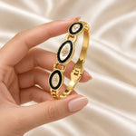 Noor Black Enamel Gold Bangle presented in hand