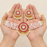Magenta kundan pearl choker necklace and earrings displayed in hands