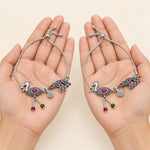 Oxidized silver peacock payal anklet pair displayed in hands
